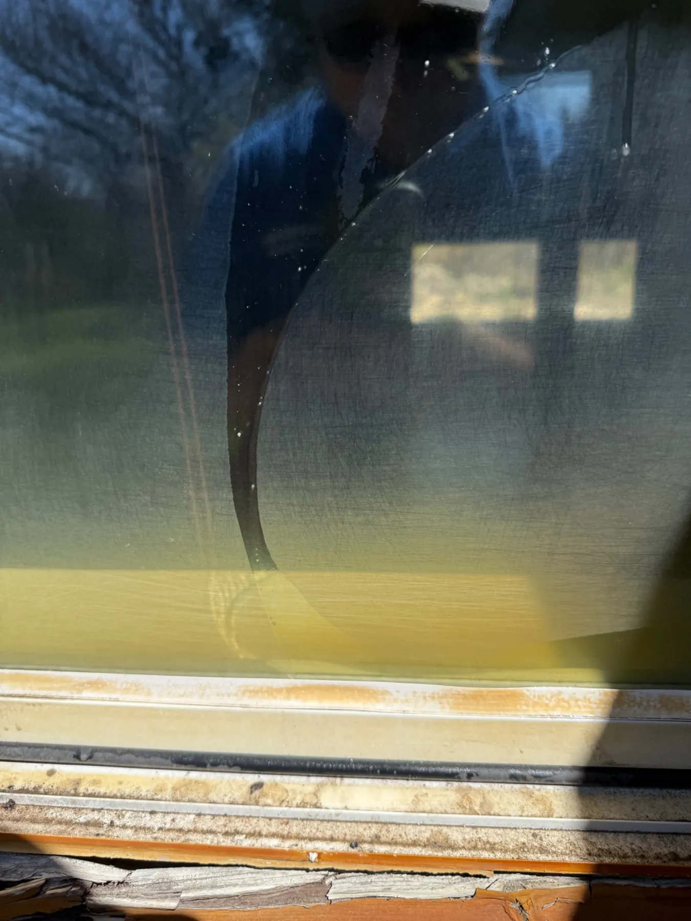 Window with mineral and rust staining caused by repeated AC condensate runoff before restoration